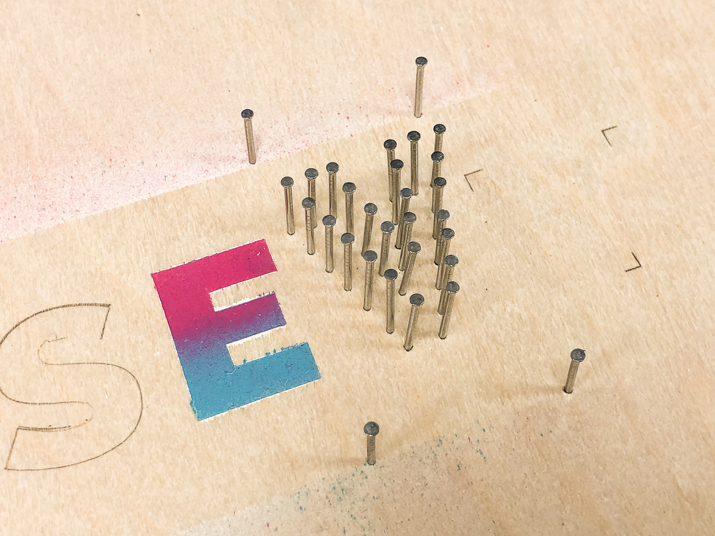 Panel pins in shape of letter V on plywood